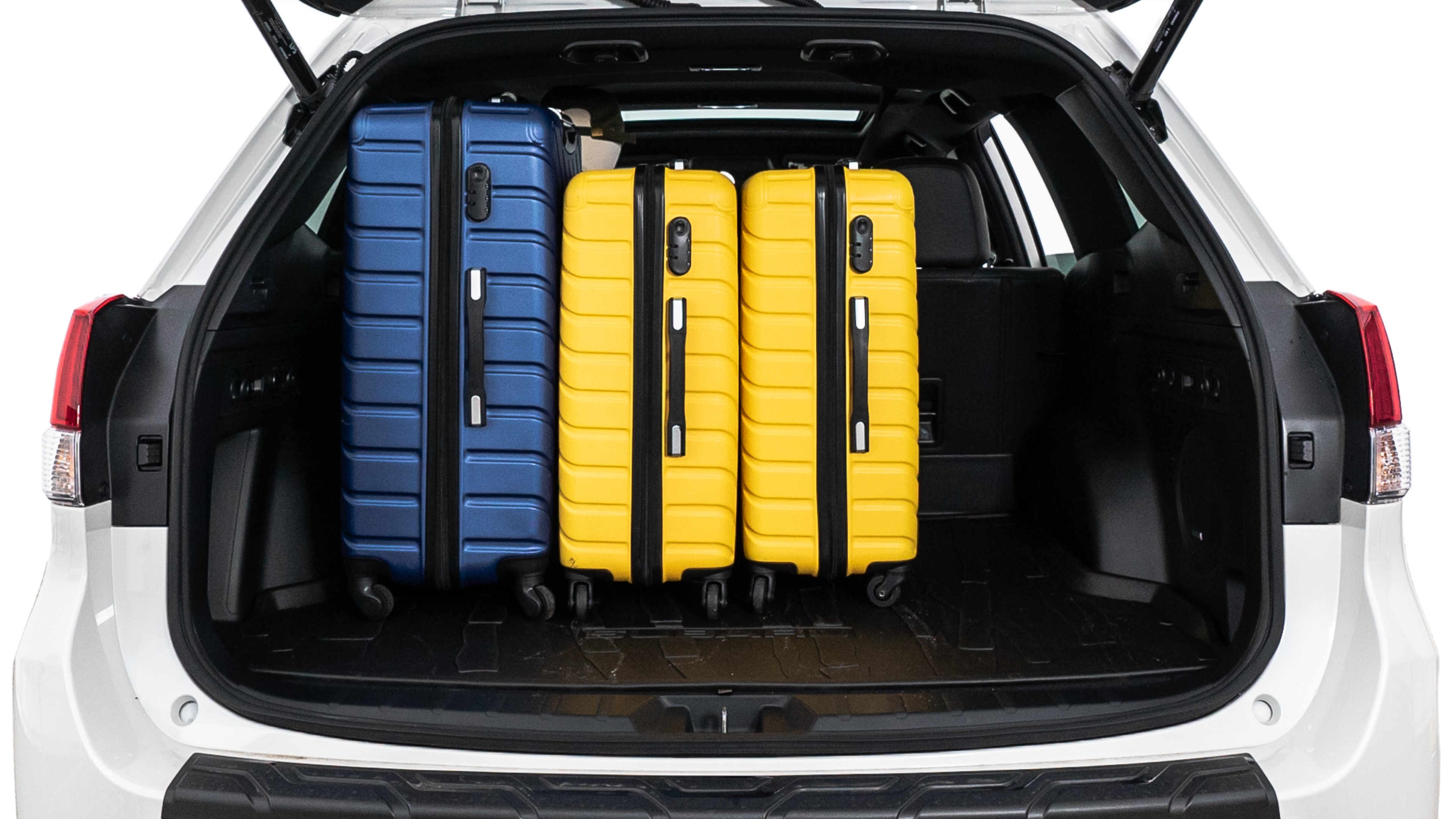 The trunk lid is open, showing full view of the trunk space. One large suitcase, two medium suitcases, and two small suitcases are placed inside.