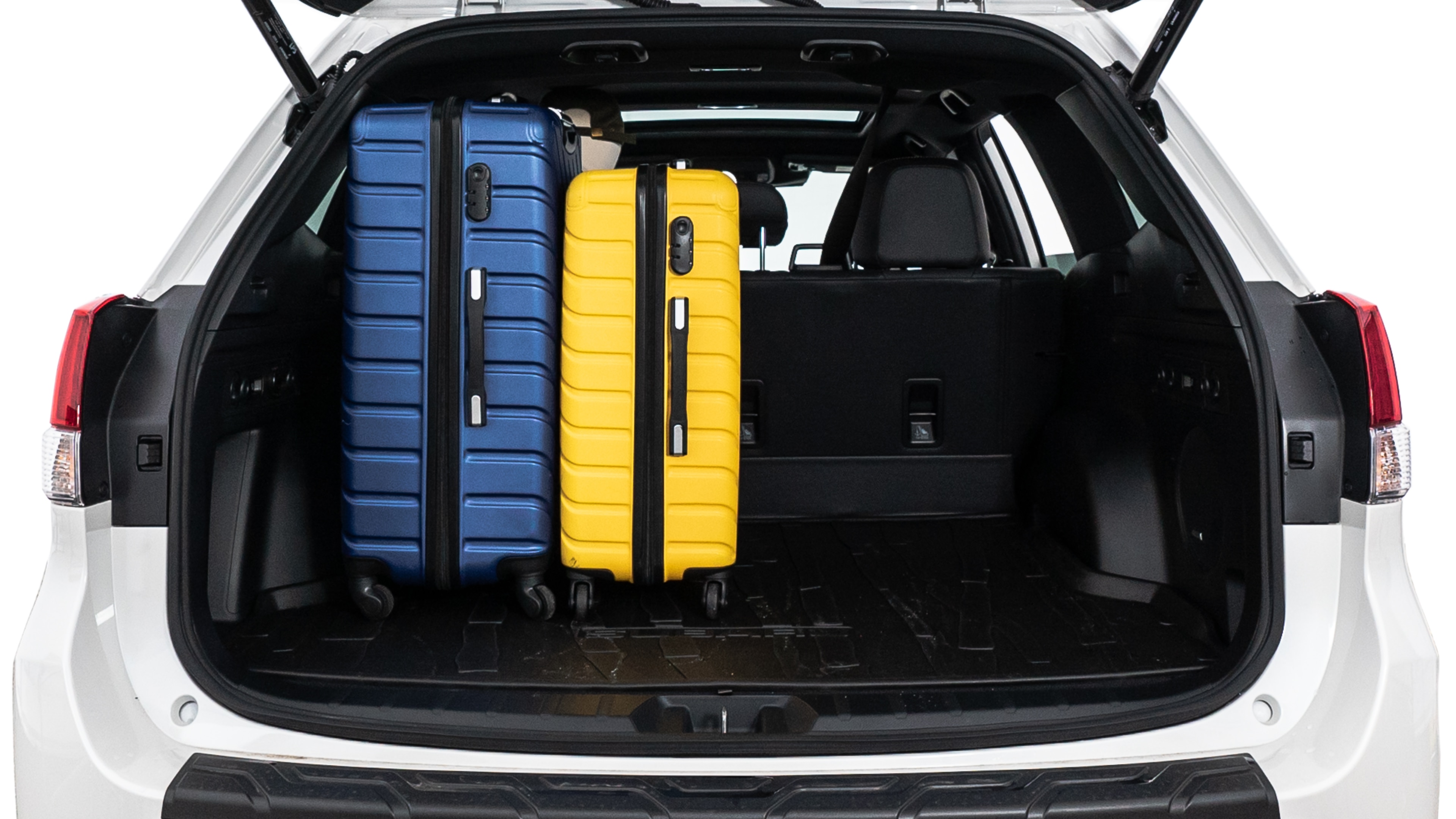 The trunk lid is open, showing full view of the trunk space. One large suitcase, two medium suitcases, and two small suitcases are placed inside.
