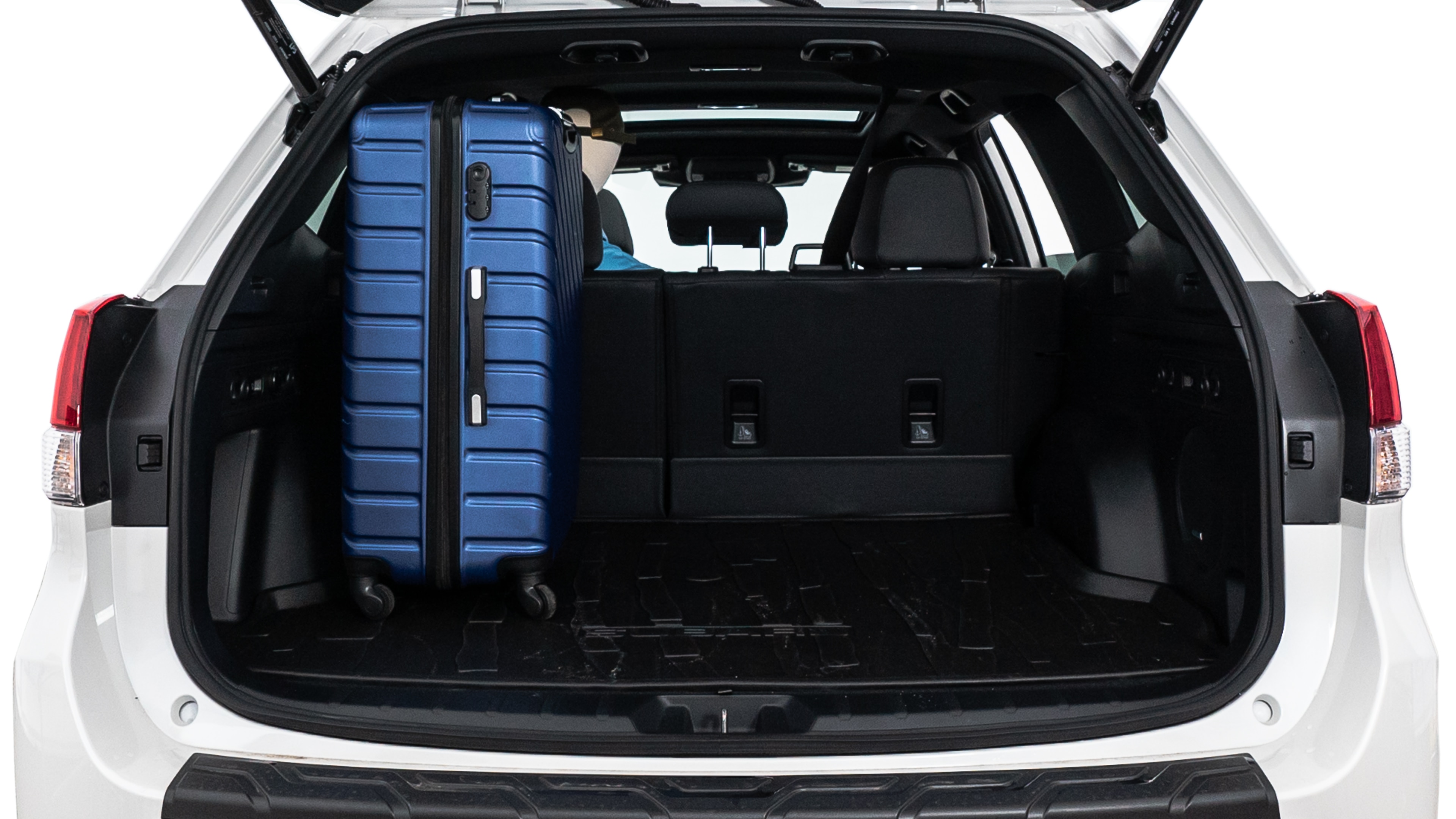 The trunk lid is open, showing full view of the trunk space. One large suitcase, two medium suitcases, and two small suitcases are placed inside.