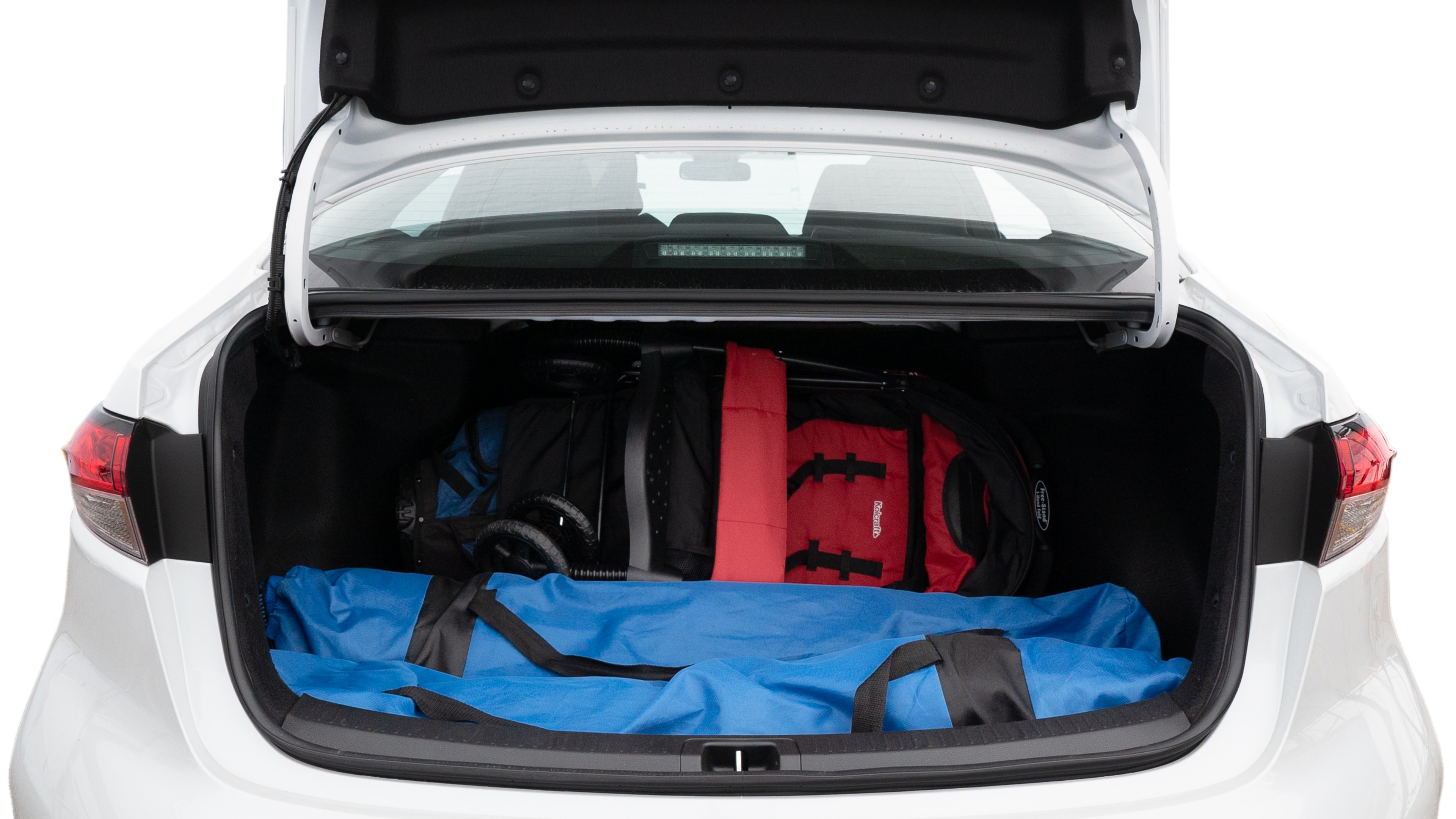 The trunk lid is open showing full view of the trunk. A baby stroller, three grocery carriers, two camping chairs in the carrying bag, and a set of golf clubs are placed inside.