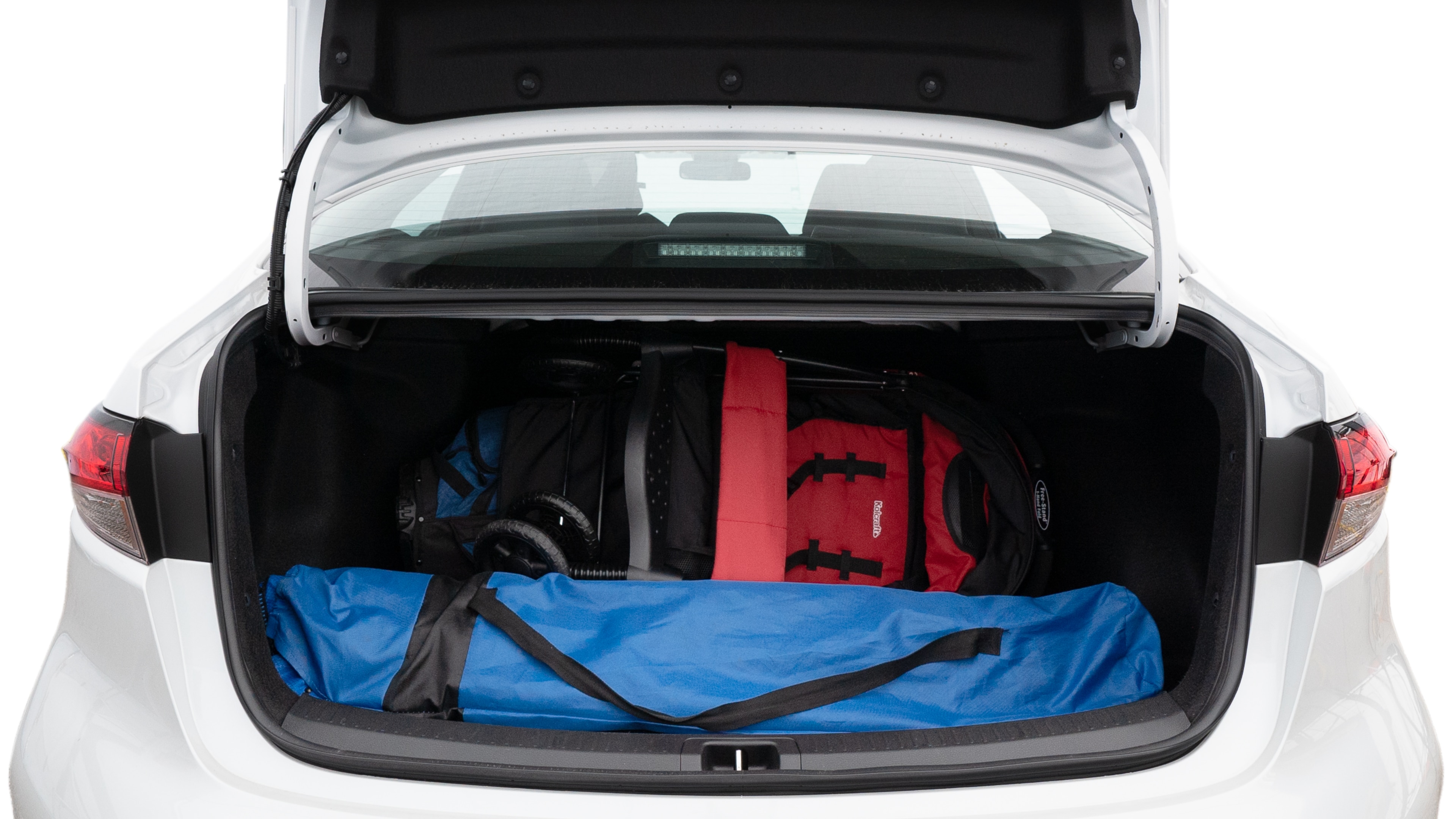 The trunk lid is open showing full view of the trunk. A baby stroller, three grocery carriers, two camping chairs in the carrying bag, and a set of golf clubs are placed inside.