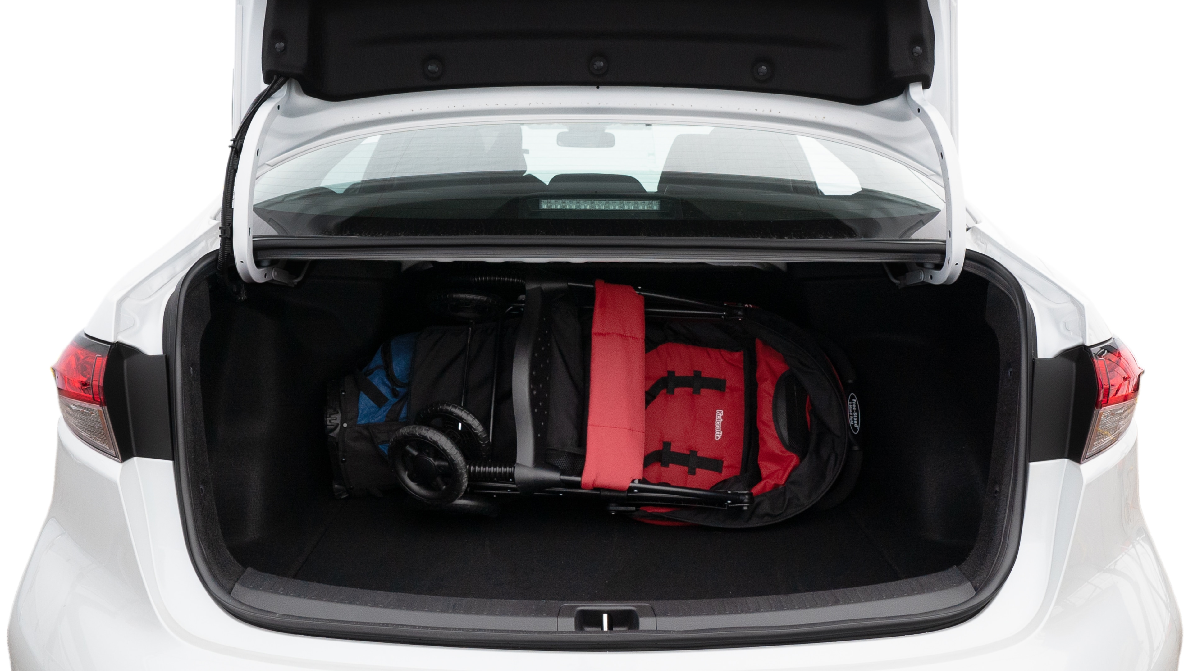The trunk lid is open showing full view of the trunk. A baby stroller, three grocery carriers, two camping chairs in the carrying bag, and a set of golf clubs are placed inside.
