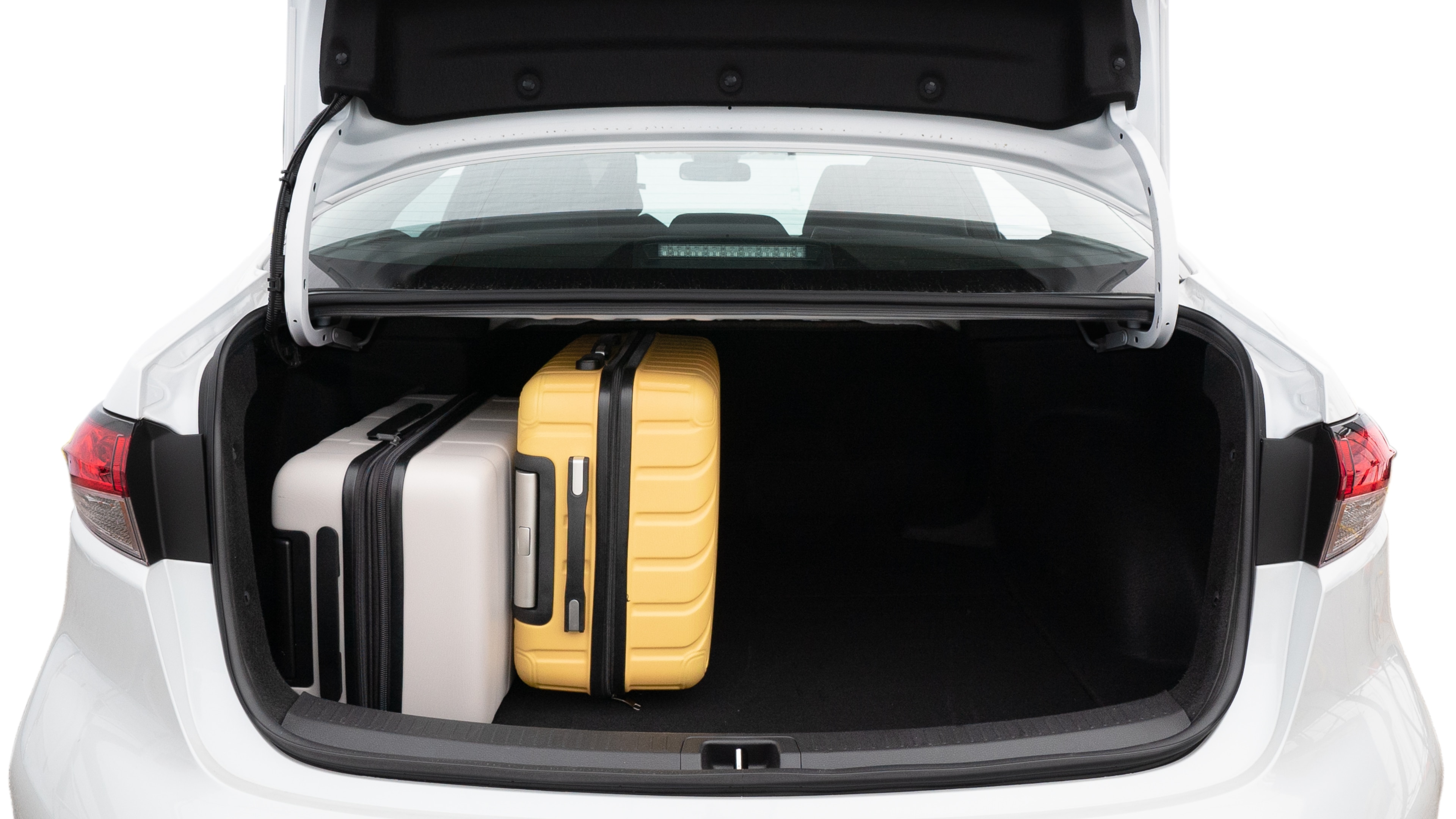 The trunk lid is open, showing full view of the trunk space. Two medium and two small suitcases are placed inside.