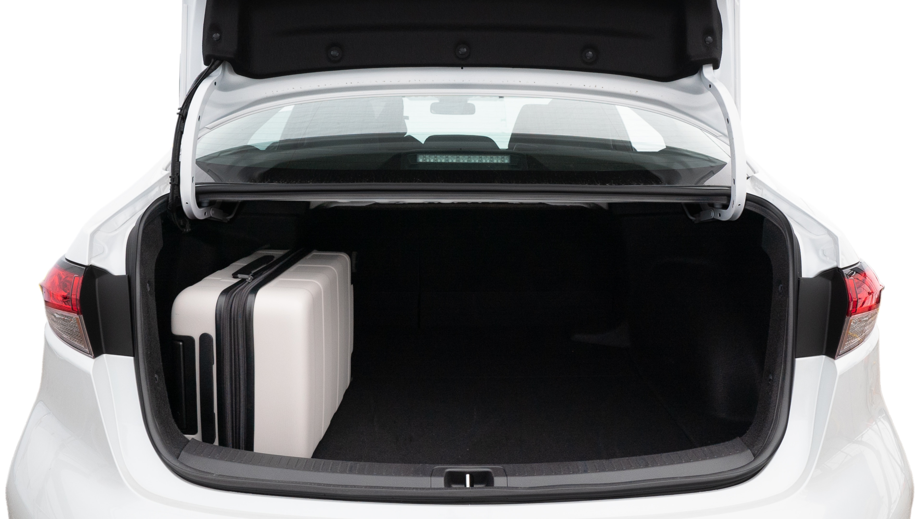 The trunk lid is open, showing full view of the trunk space. Two medium and two small suitcases are placed inside.